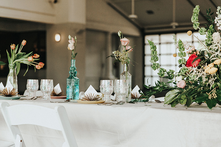 Single Stem Flowers in Antique Bottles Wedding Decor | photo by Deltalow | featured on I Do Y'all