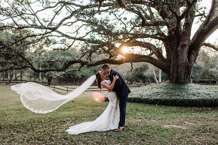 Bride & Groom in front of oak tress at The Venue at Southern Oaks | photo by MbM Photography | featured on I Do Y'all