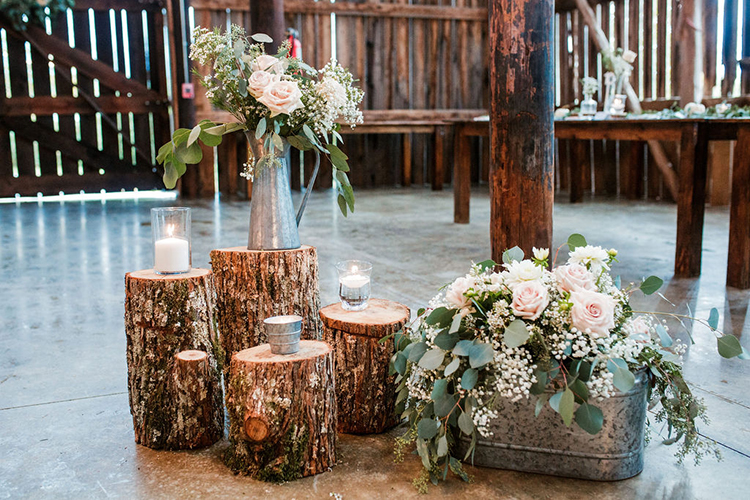 Rustic wedding decor of wood stumps and tin vases | photo by John Myers Photography | featured on I Do Y'all