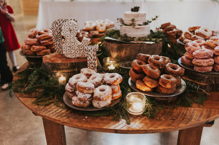 Donuts at Wedding on Round Farm Table with Pine Decor & Candles | photo by Jen Menard Photography