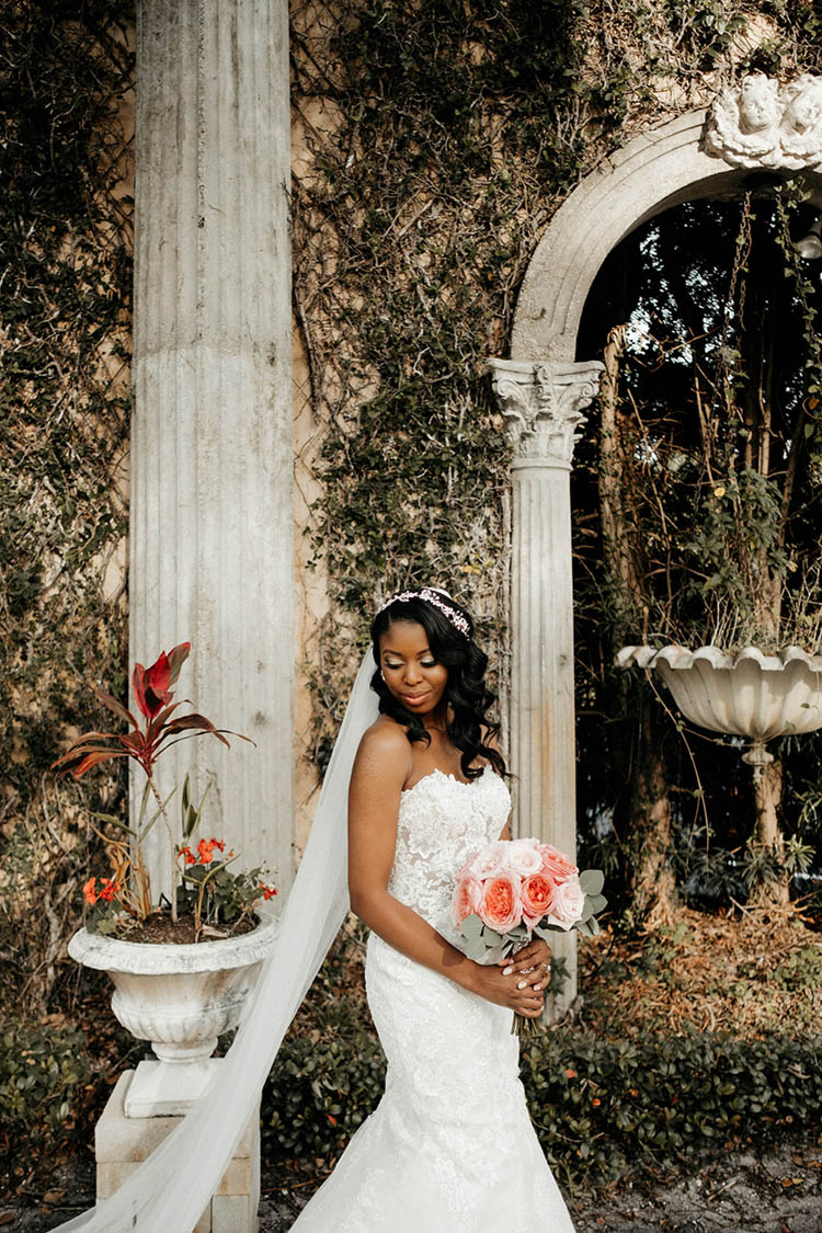 Bride in Fitted Lace Mermaid Style Dress with Illusion Cutouts and Long Veil | photo by The Portos